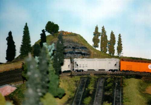 A slow freight passes the end of the yard near Briggs Hill